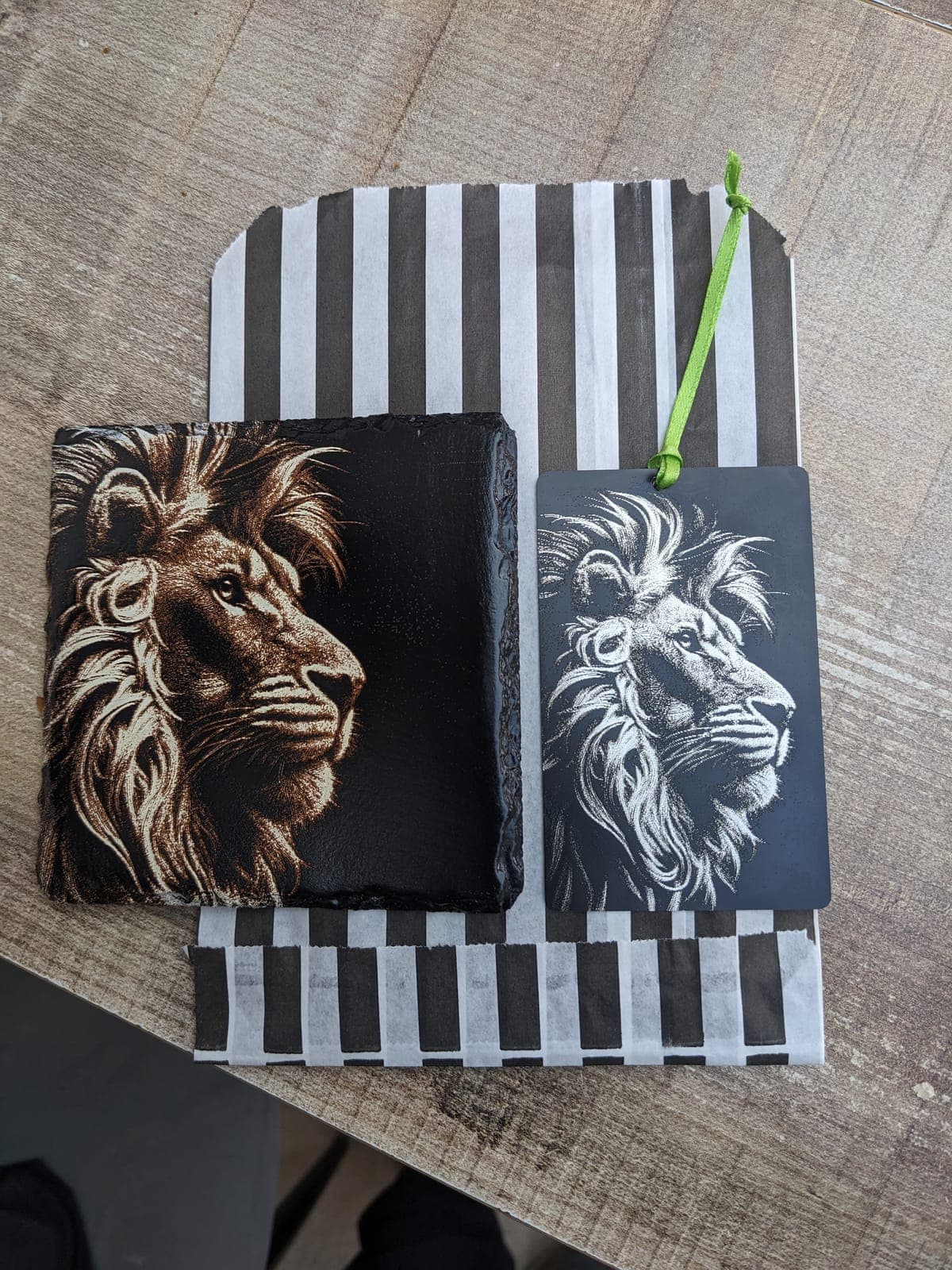 A lion engraved on a slate, beside a matching lion gift tag