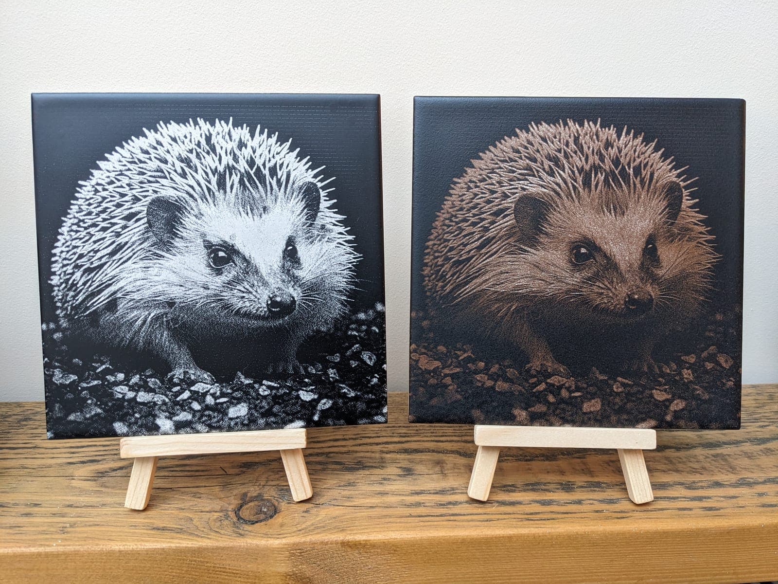 Two hedgehog tiles on small wooden easels, one in black and white, one in brown