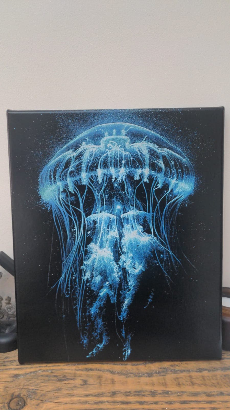 A glowing blue jellyfish on a black background